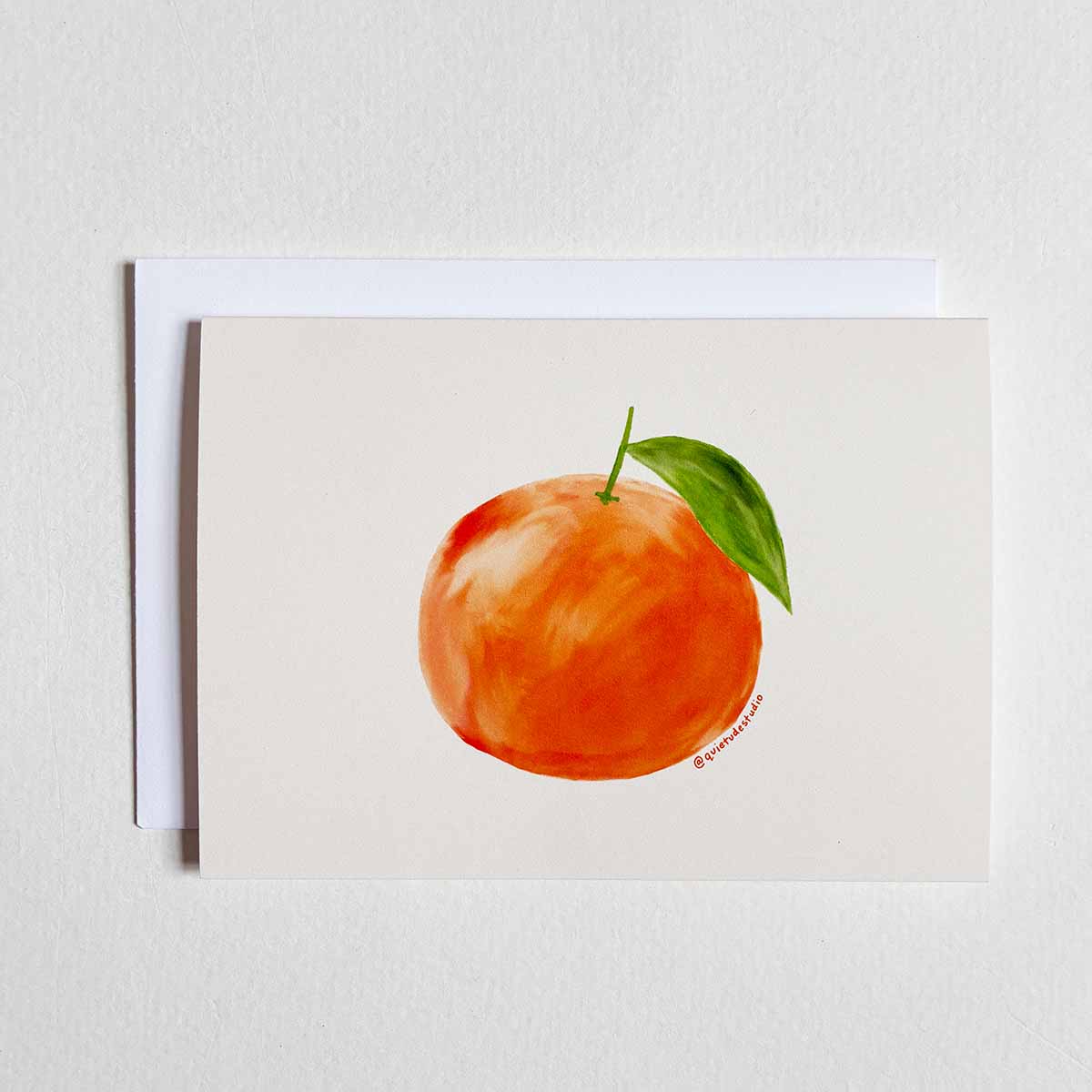 Card with a watercolor illustration of an orange on a beige background