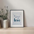 Framed artwork with motivational quote Do more of what you love on a shelf with a vase and plant.