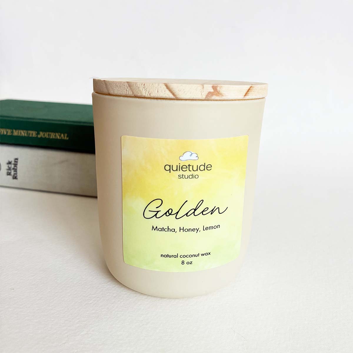 matcha, honey and lemon coconut soy candle in a jar with books in the background