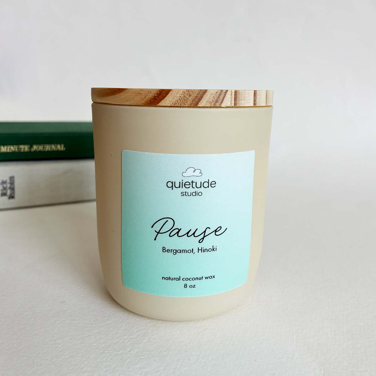 bergamot hinoki soy candle with books in the background