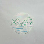 Round suncatcher vinyl sticker with mountain and water design on a white background