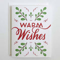 Greeting card with 'Warm Wishes' text and green leaf designs on a white background